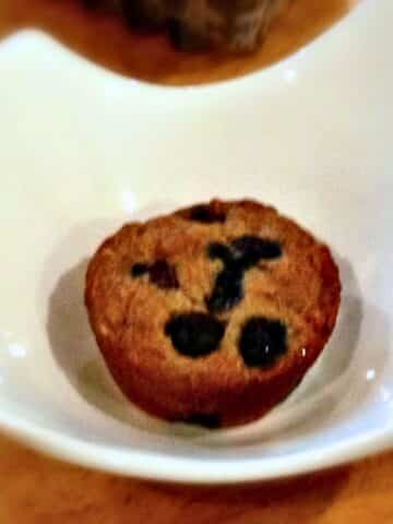 A blueberry muffin sitting inside a white bowl.