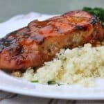 glazed pork cooked and served on a white plate with cauliflower rice.