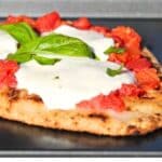Close up of a margherita style naan pizza.