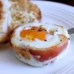 Pancetta egg cup prepared on a white dish.