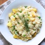 Aerial view of prepared vegetable risotto in a white square dish.