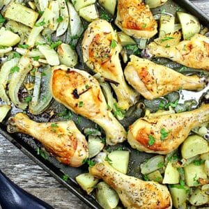 cooked drumsticks and vegetables on a sheet pan