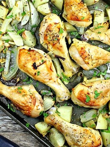cooked drumsticks and vegetables on a sheet pan