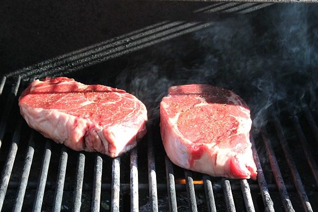 raw steaks on grill