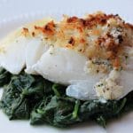 lemon baked cod topped with crumbs on spinach