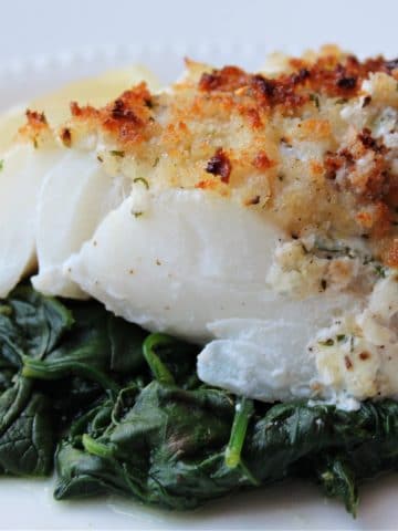 lemon baked cod topped with crumbs on spinach