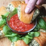 stuffed crescent roll getting dipped into sauce