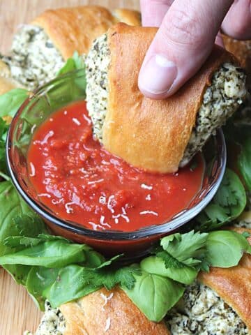 stuffed crescent roll getting dipped into sauce