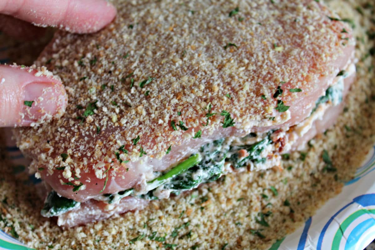 pork stuffed and being coated in breadcrumbs