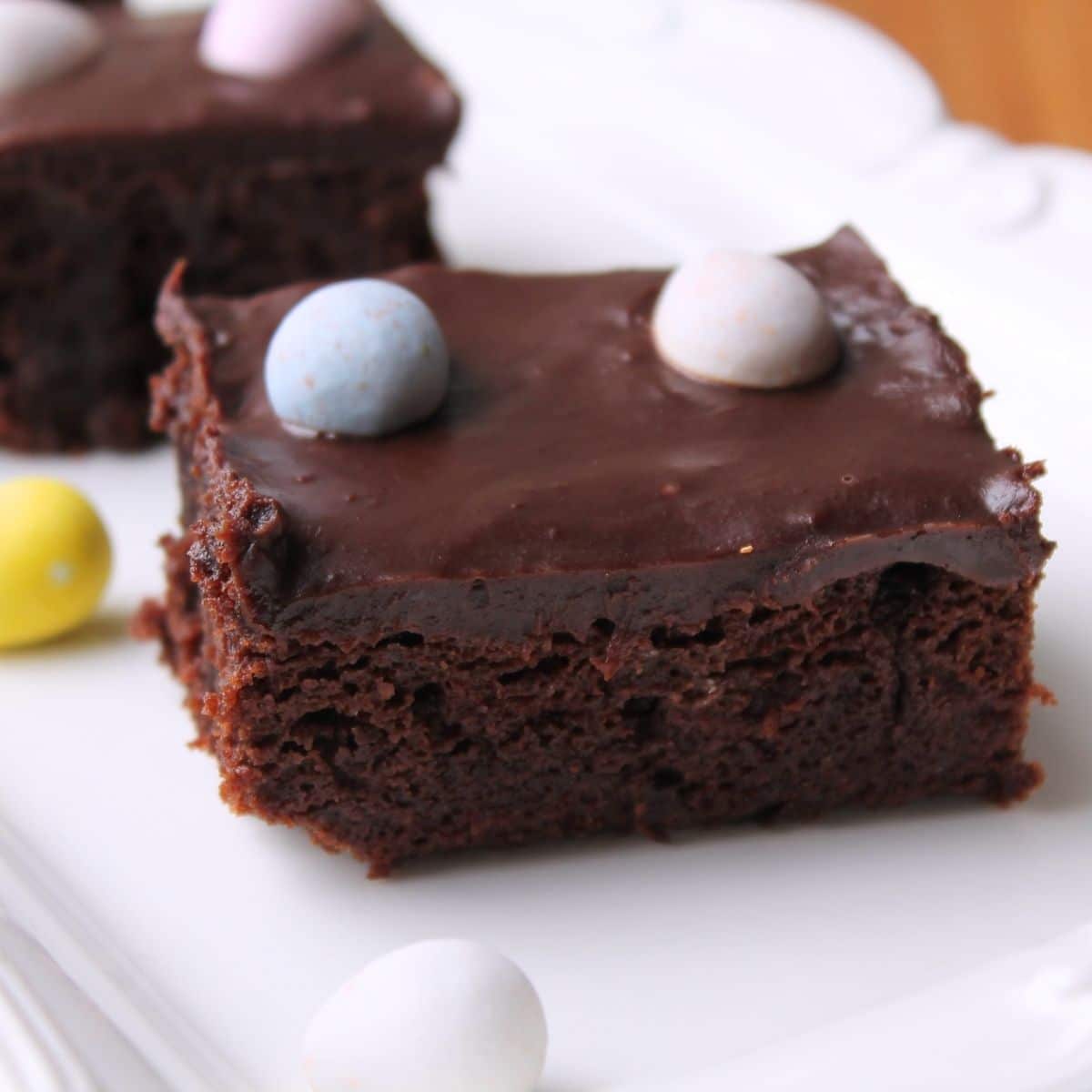 Mini egg brownies on a white serving tray.