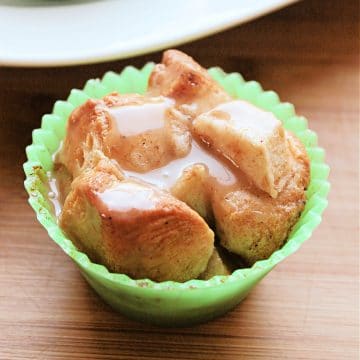closeup of monkey bread cupcake in green silicone liner sitting on a wood cutting board