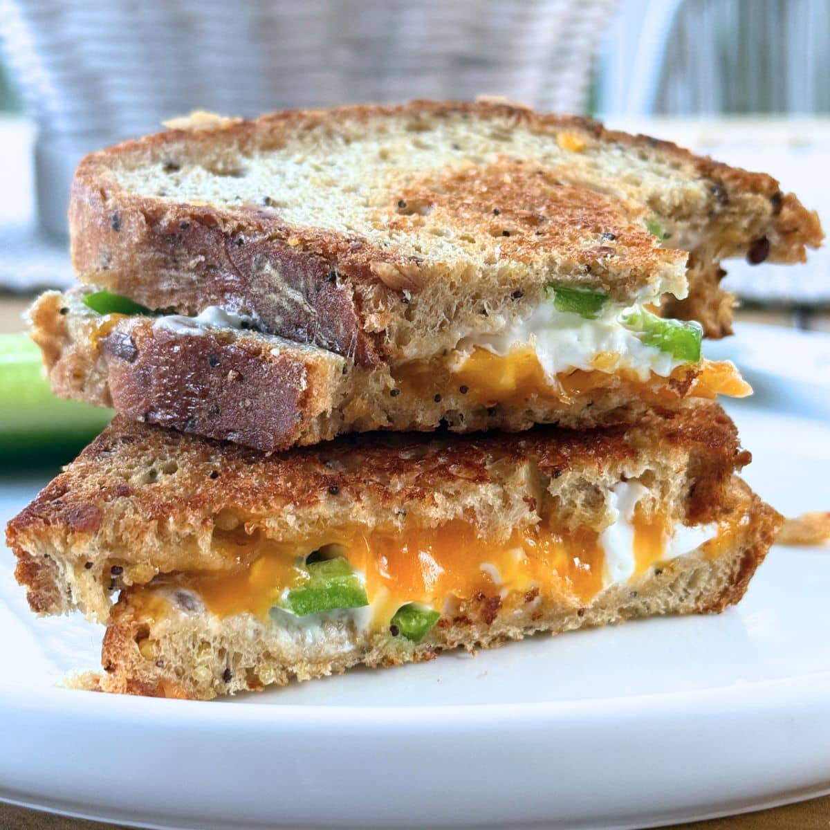 Two halves of the sandwich stacked on each other on a white dish.