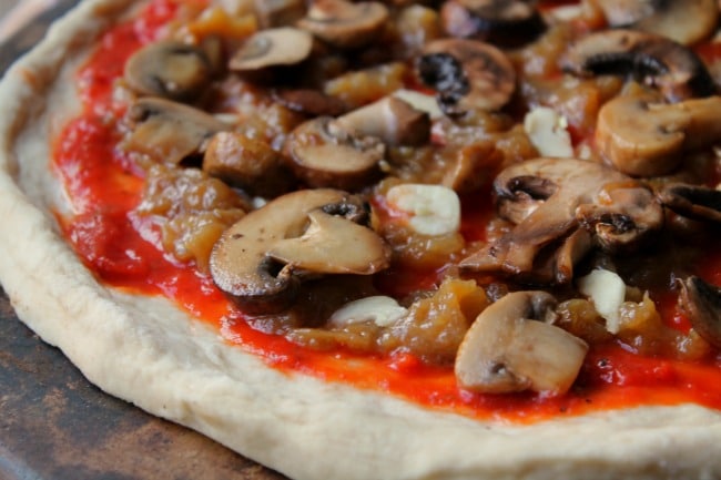 close up caramelized onions and mushrooms on pizza