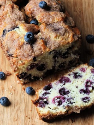 blueberry bread on cutting board with a slice cut