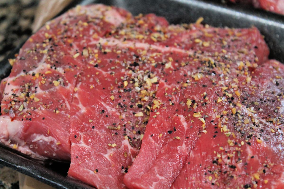 raw beef with seasoning in packaging tray