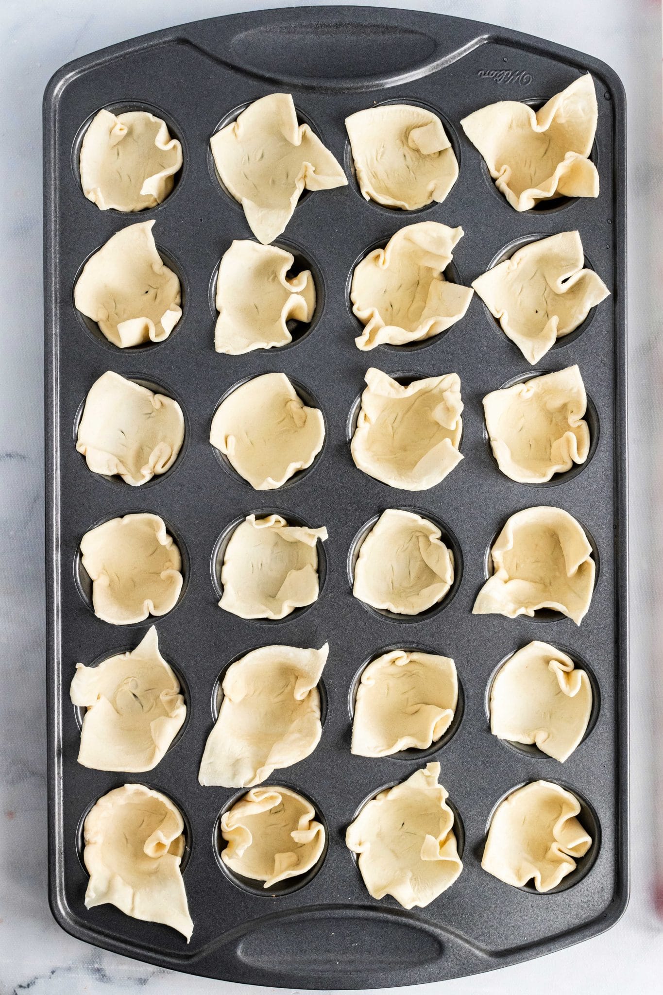 puff pastry squares arranged in mini muffin tin