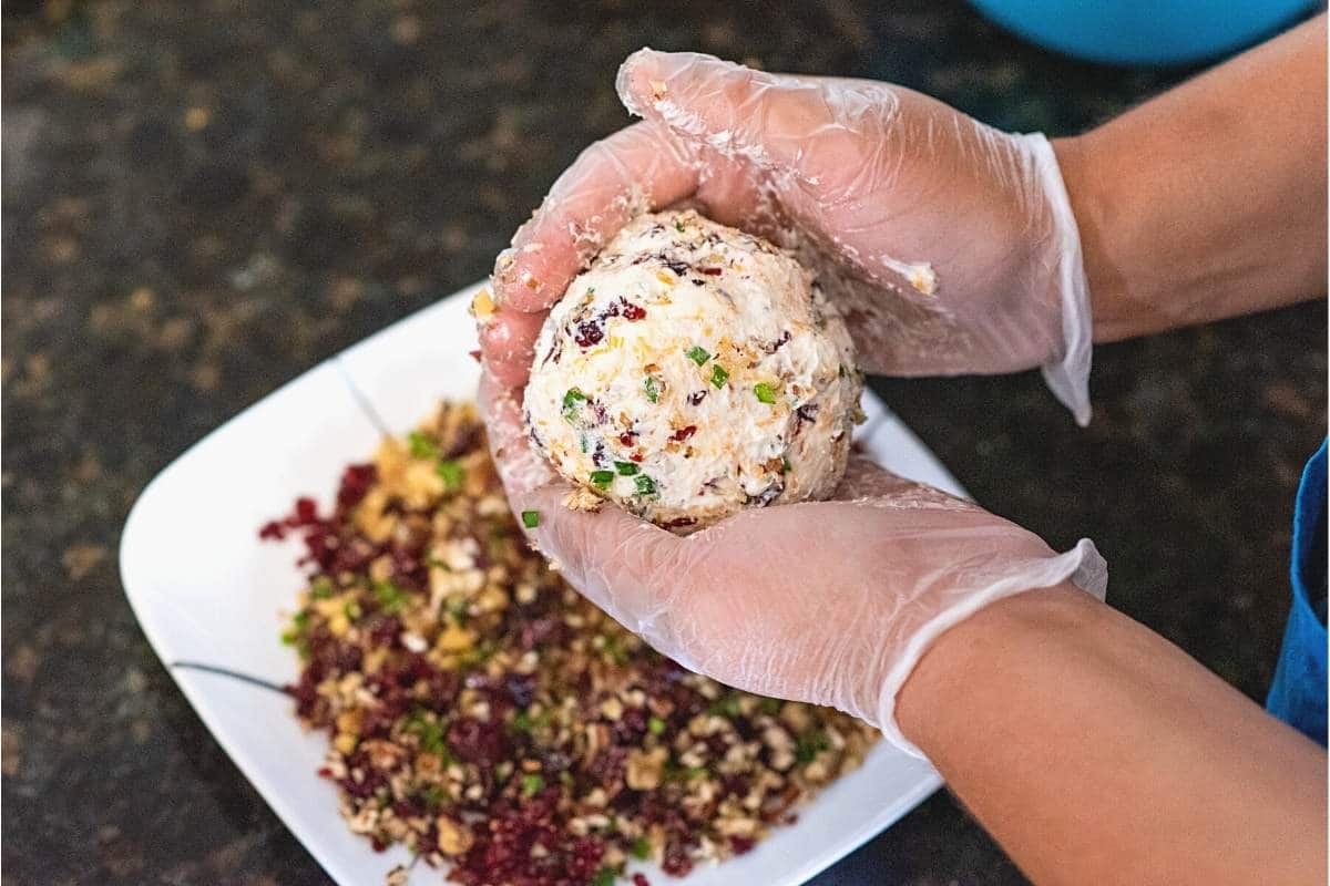 gloved hands forming the cheese ball