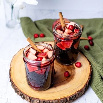 two glasses of sangria sitting on a wooden trivet