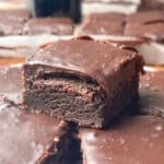 Ganache covered brownies with one brownie on top of all the others.