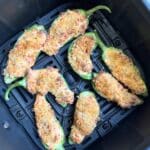 Cooked jalapeno poppers in the air fryer basket. Aerial view.