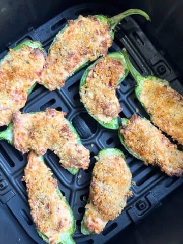 Cooked jalapeno poppers in the air fryer basket. Aerial view.