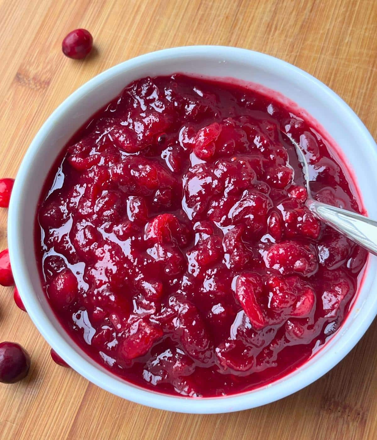 Close up view of prepared cranberry sauce in a white bowl.