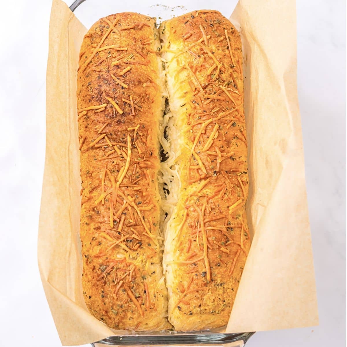 A baked loaf of crescent bread still in the loaf pan.